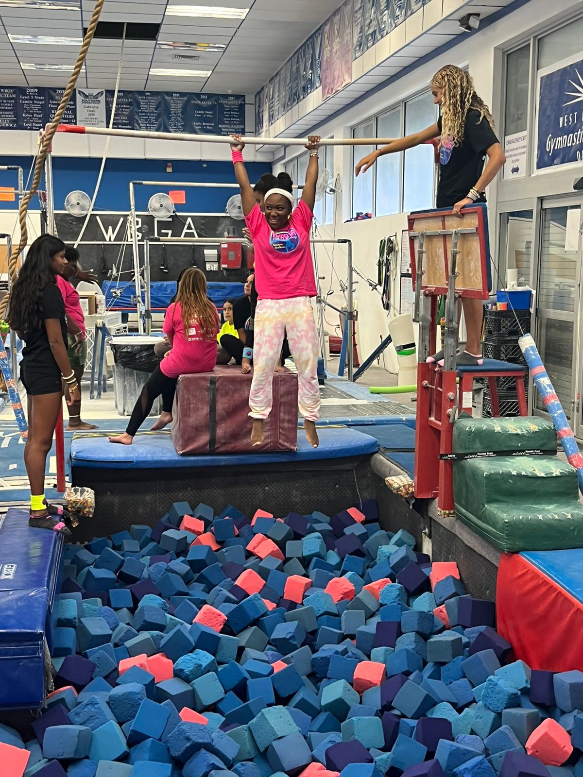 Campers at Camp Katina practice on a gymnastics bar.