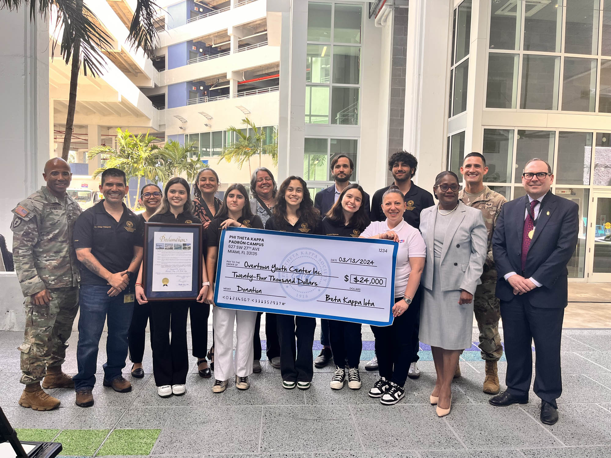 Students from Miami-Dade College present a donation check to the Super Saturdays Program.