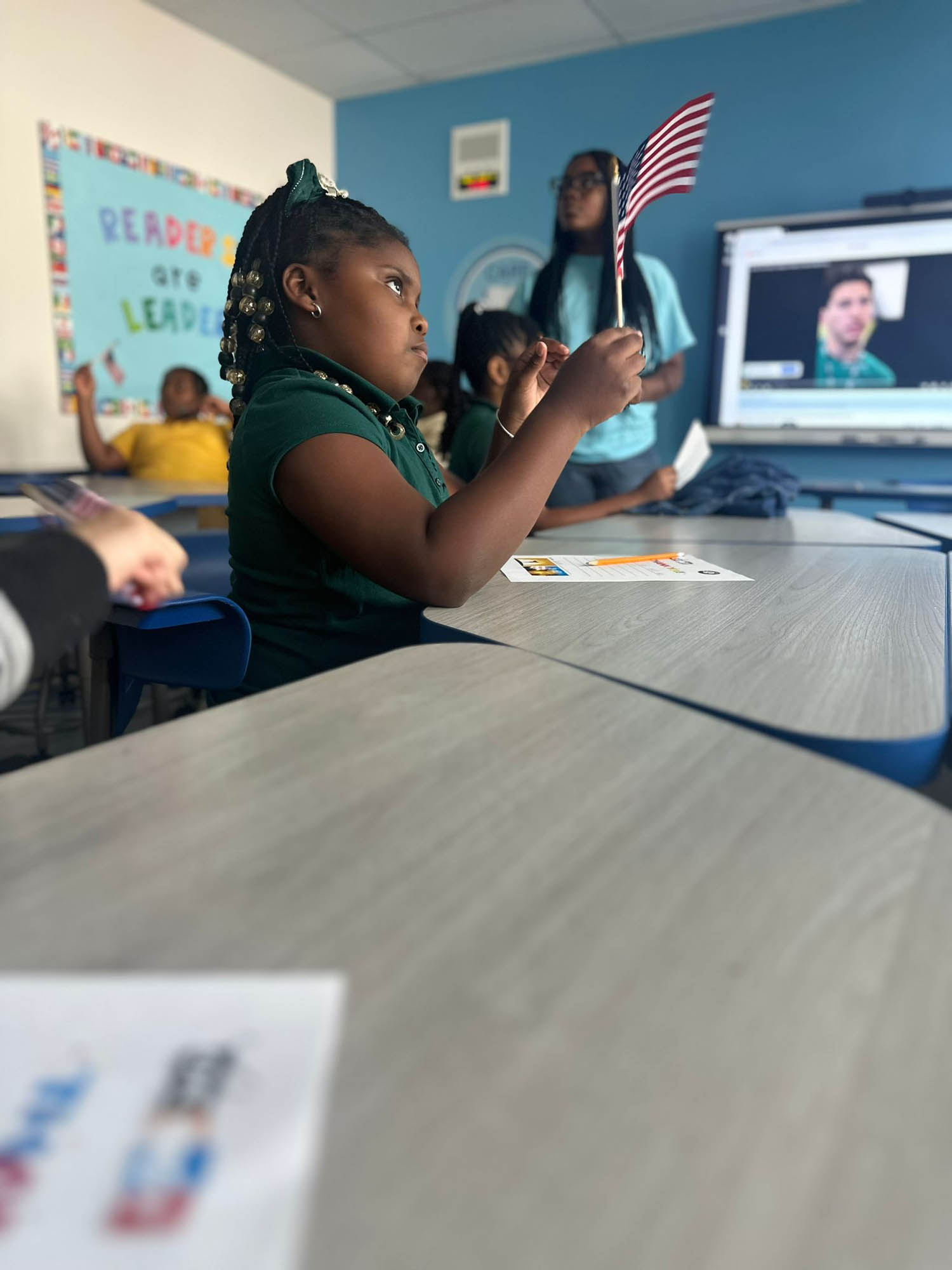 a child in a classroom engages in a presentation at OYC Miami