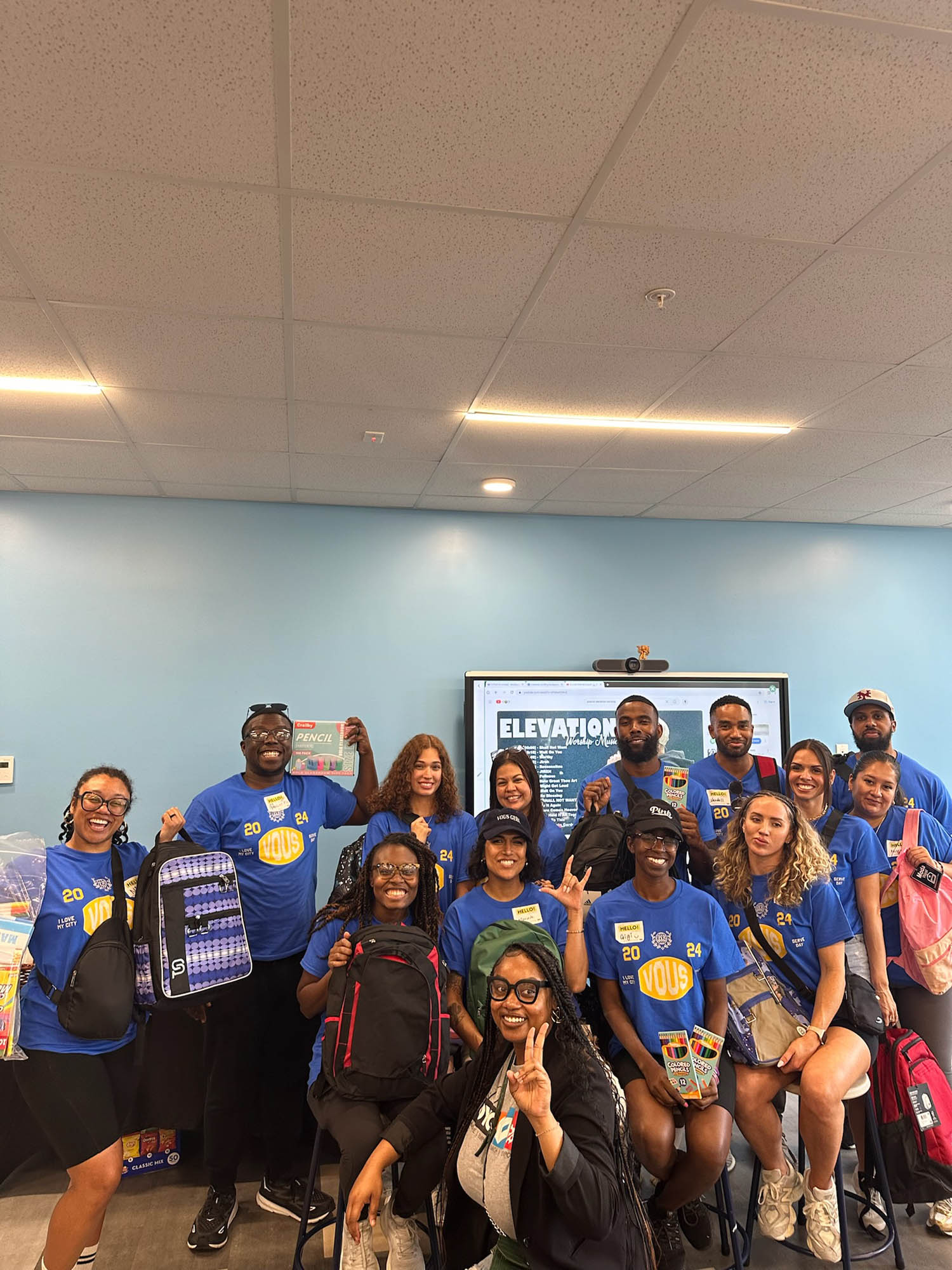 a group of smiling volunteers wearing Vous Church shirts