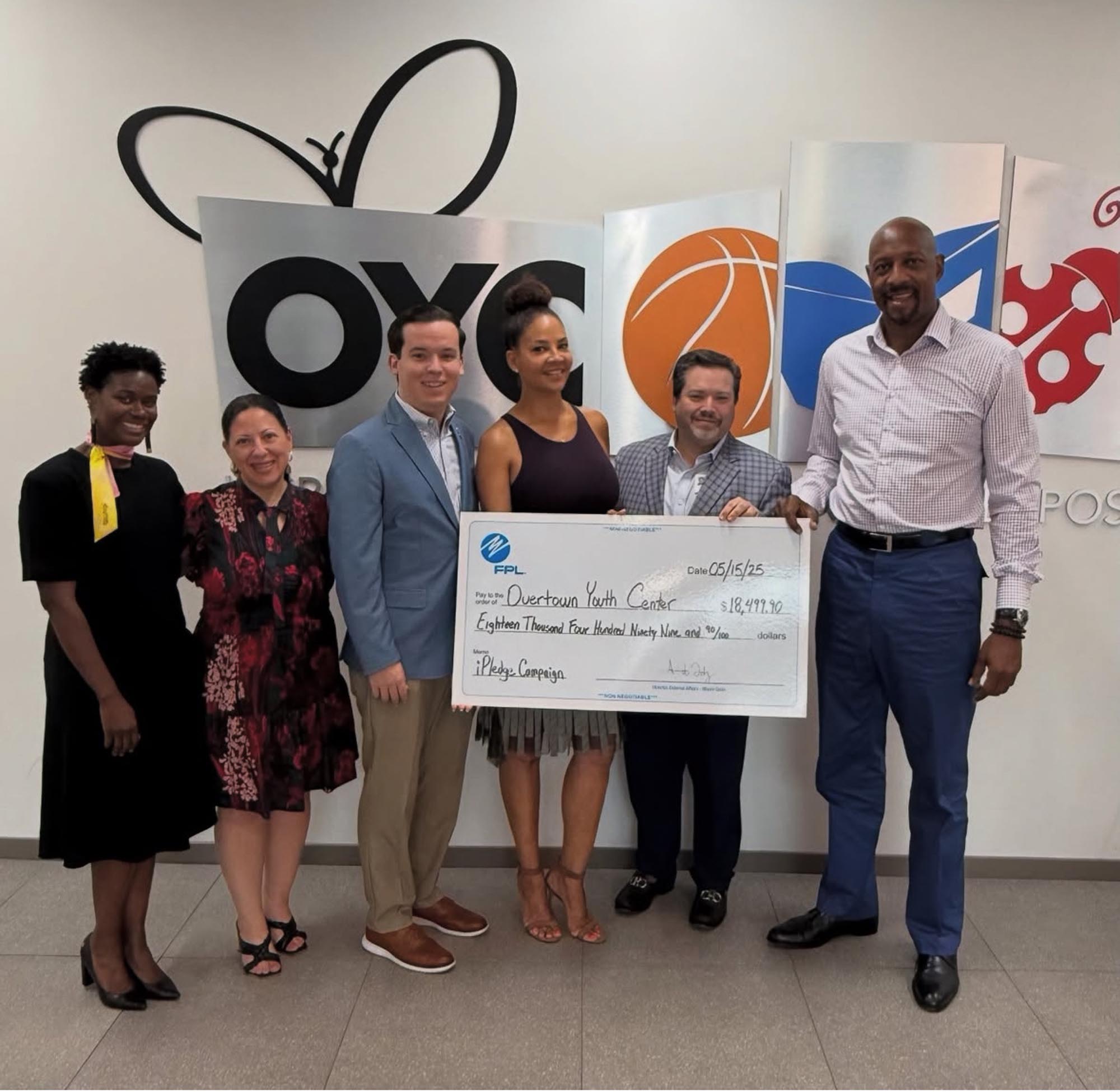 OYC staff receive a large check from FPL