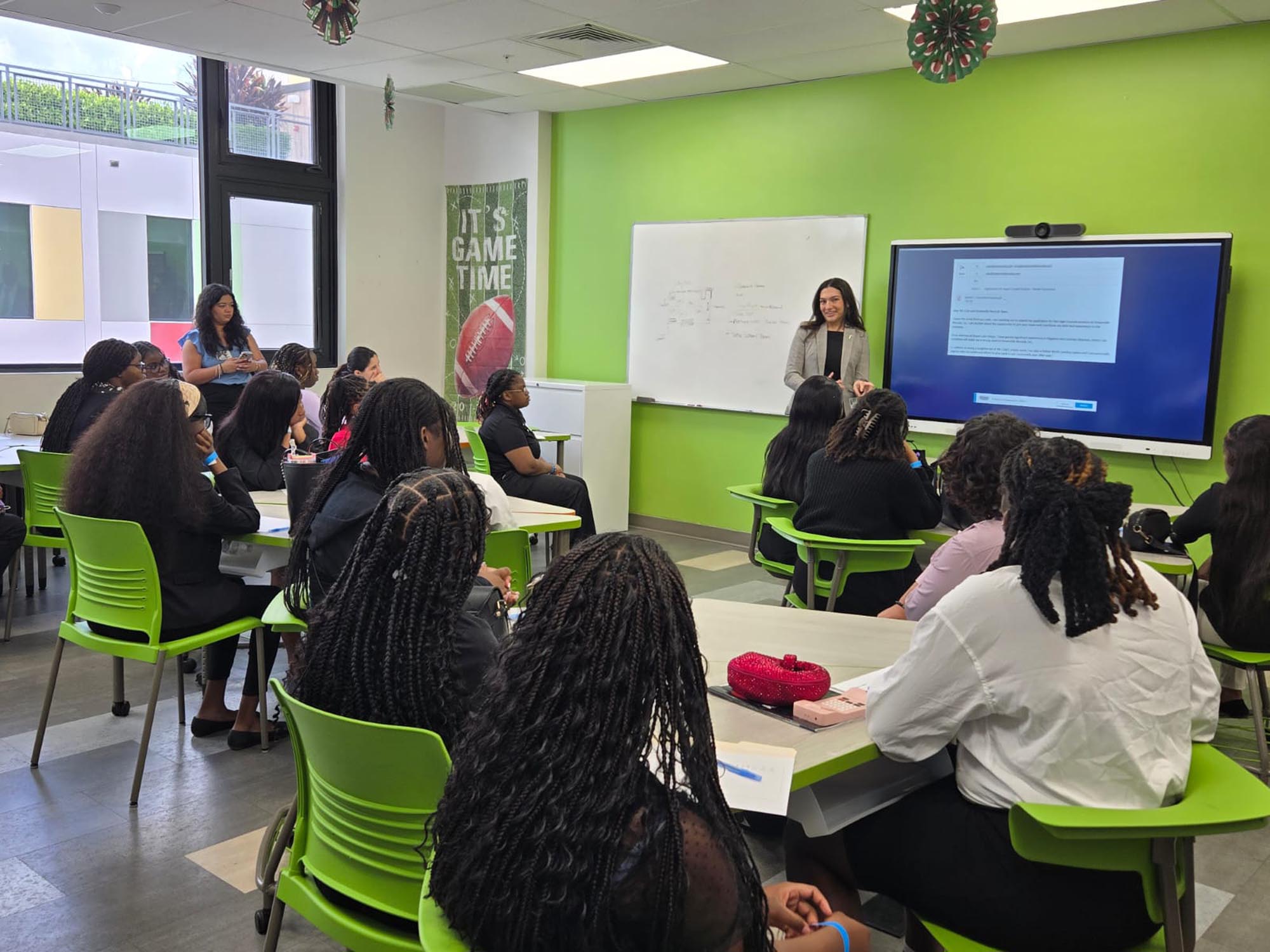 a group of summer interns are briefed in a classroom