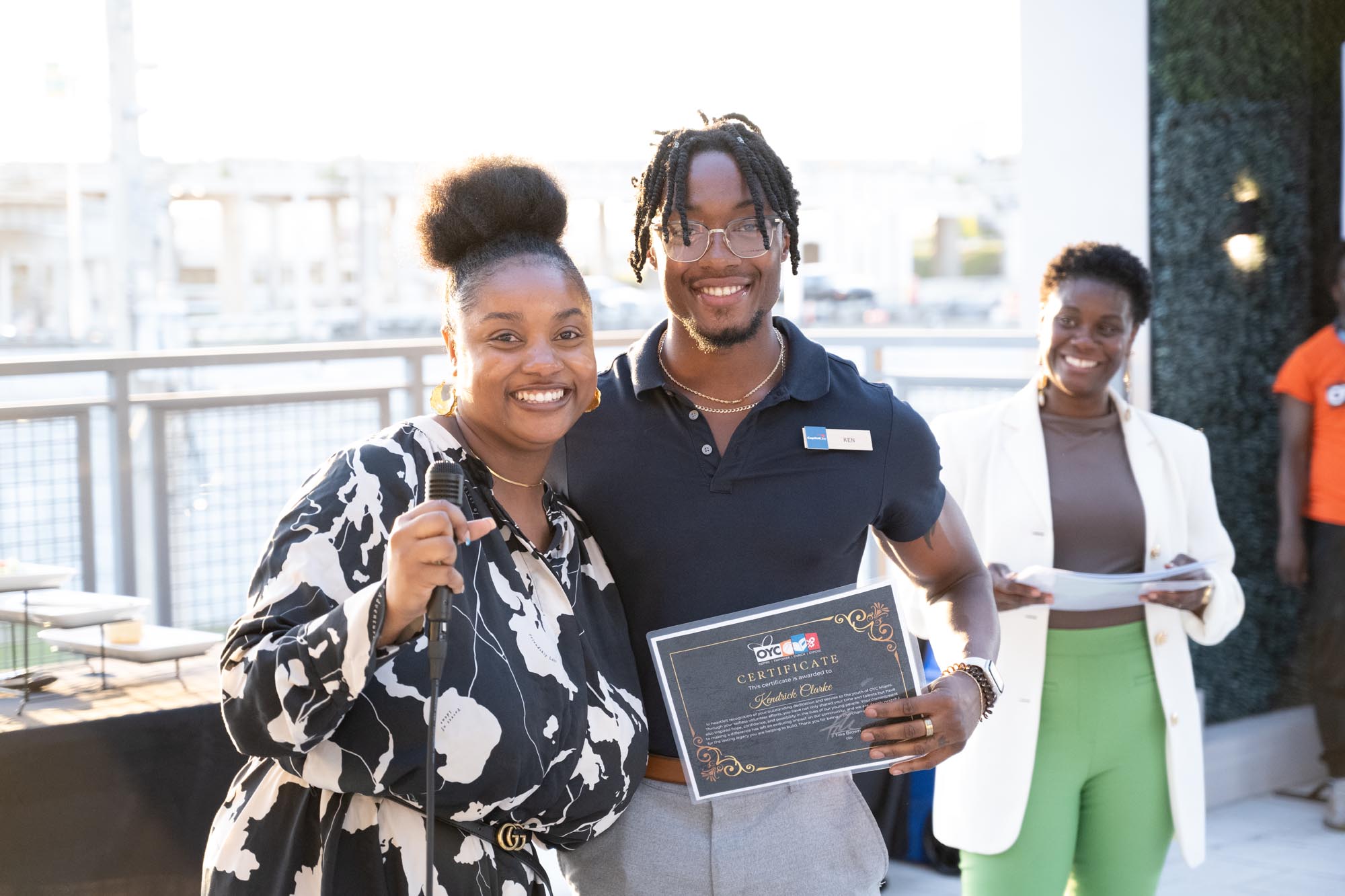 Two volunteers display a certificate of appreciation