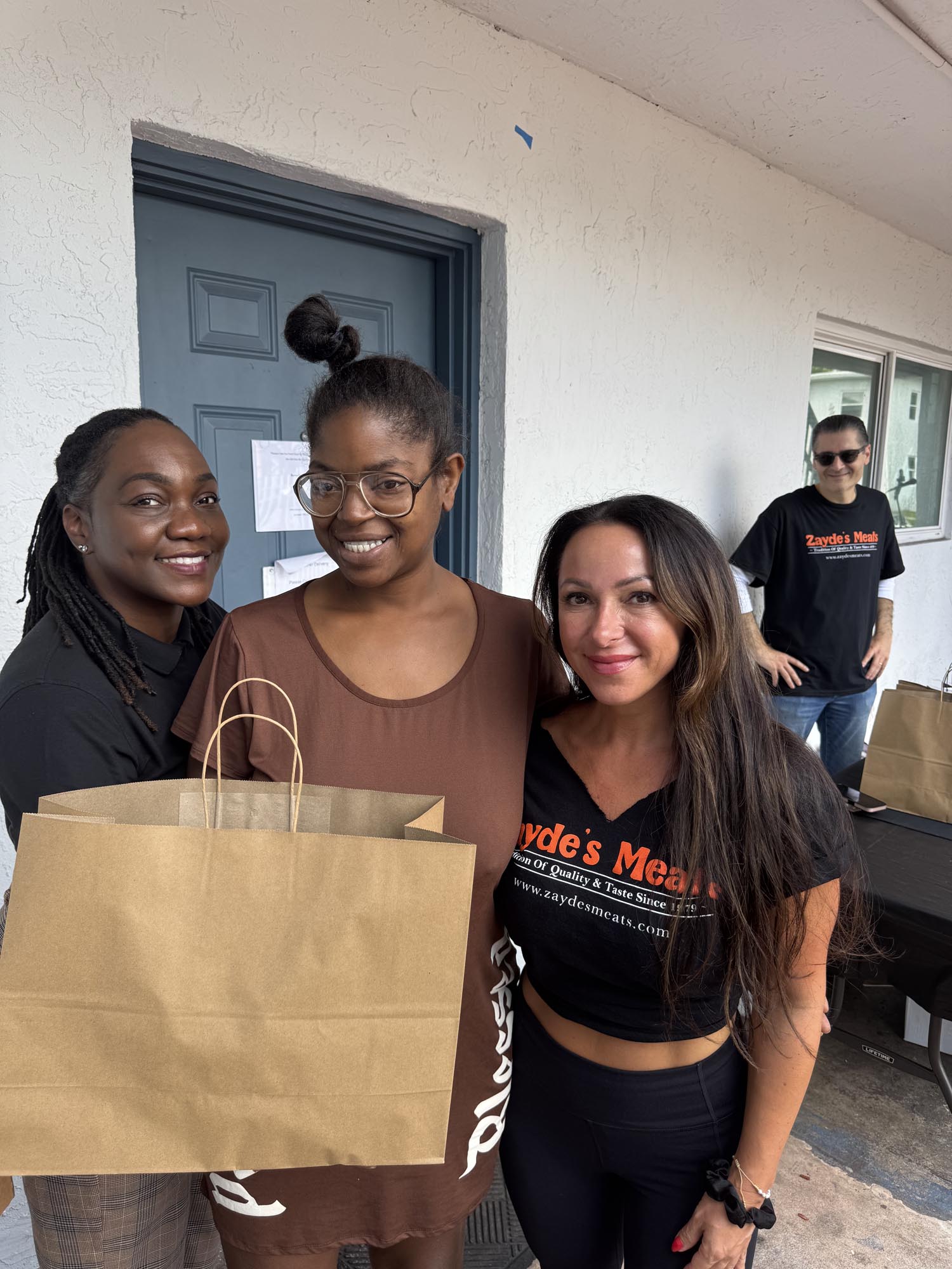 three women and a paper shopping bag