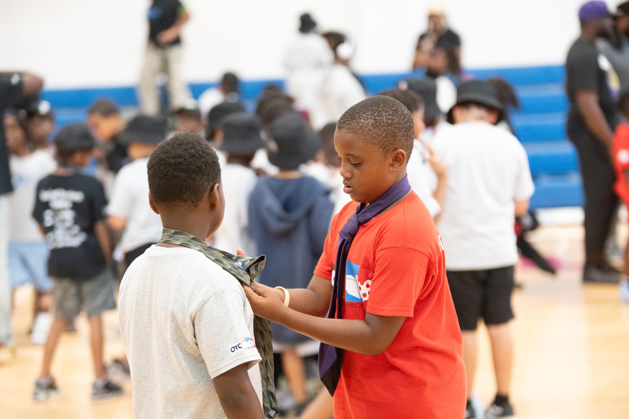 two young boys interact inside a gymnasium