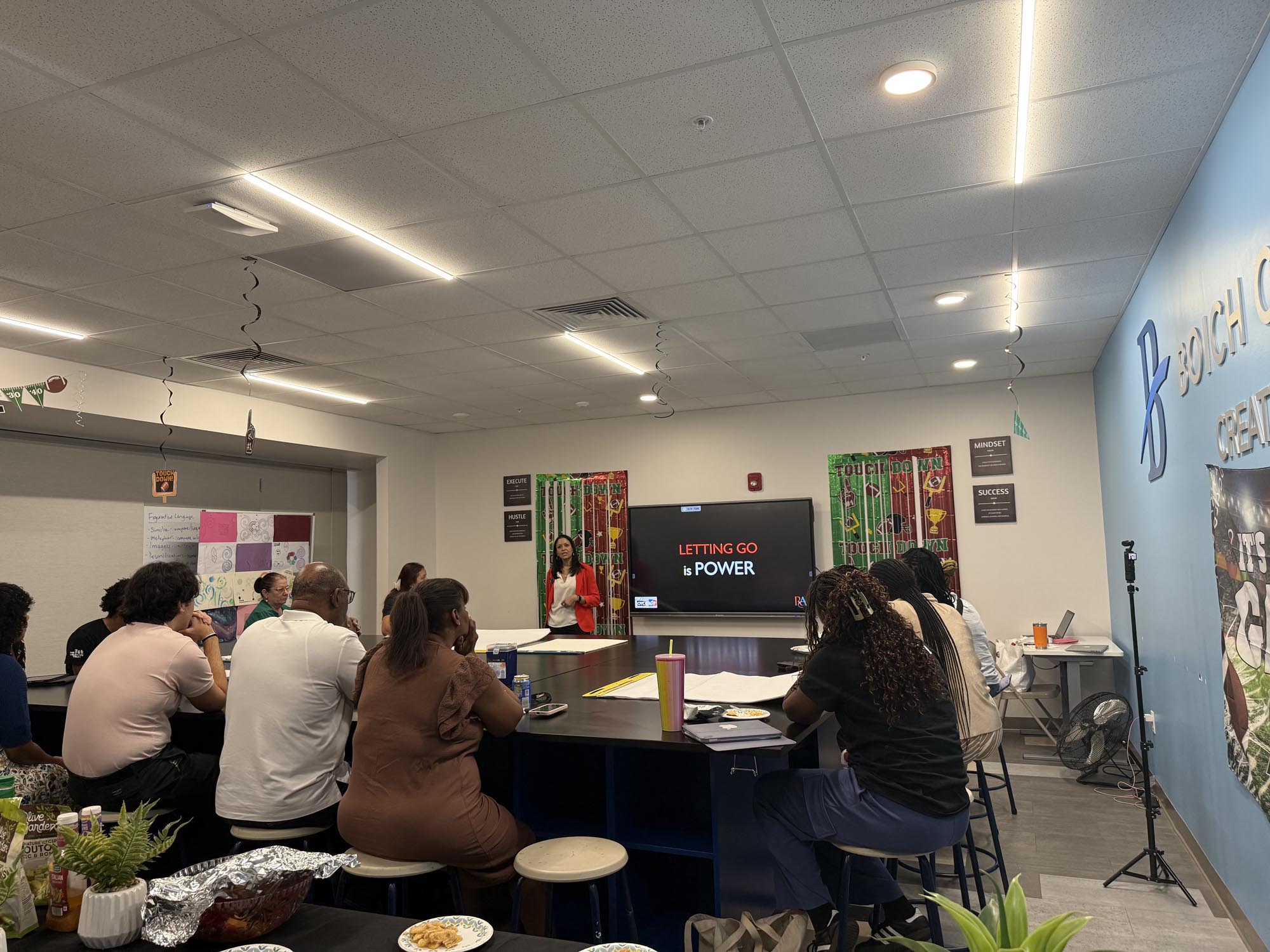a motivational speaker gives a speech to a group of people in a room
