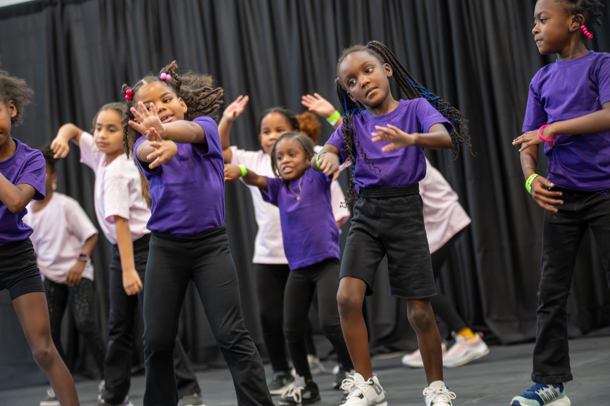 a group of young children performs on stage