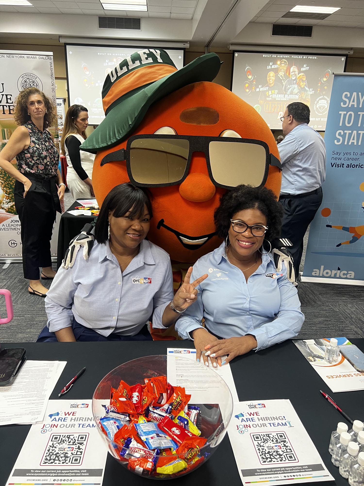 two women with a large orange character behind them