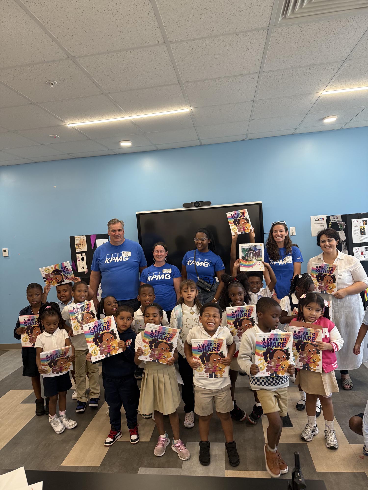 a group of children hold up books that were given to them