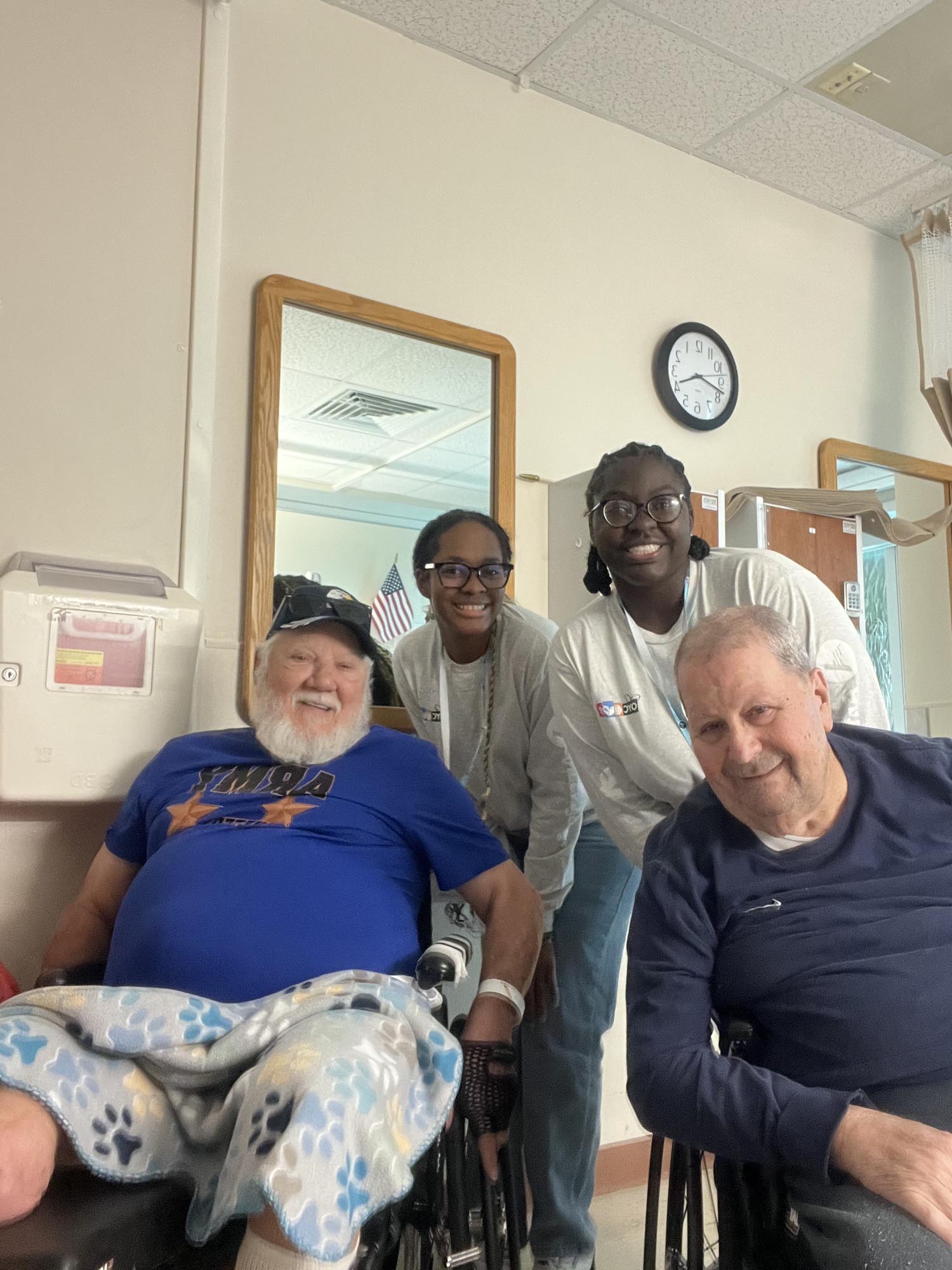two OYC AmeriCorps members with two veterans in wheelchairs