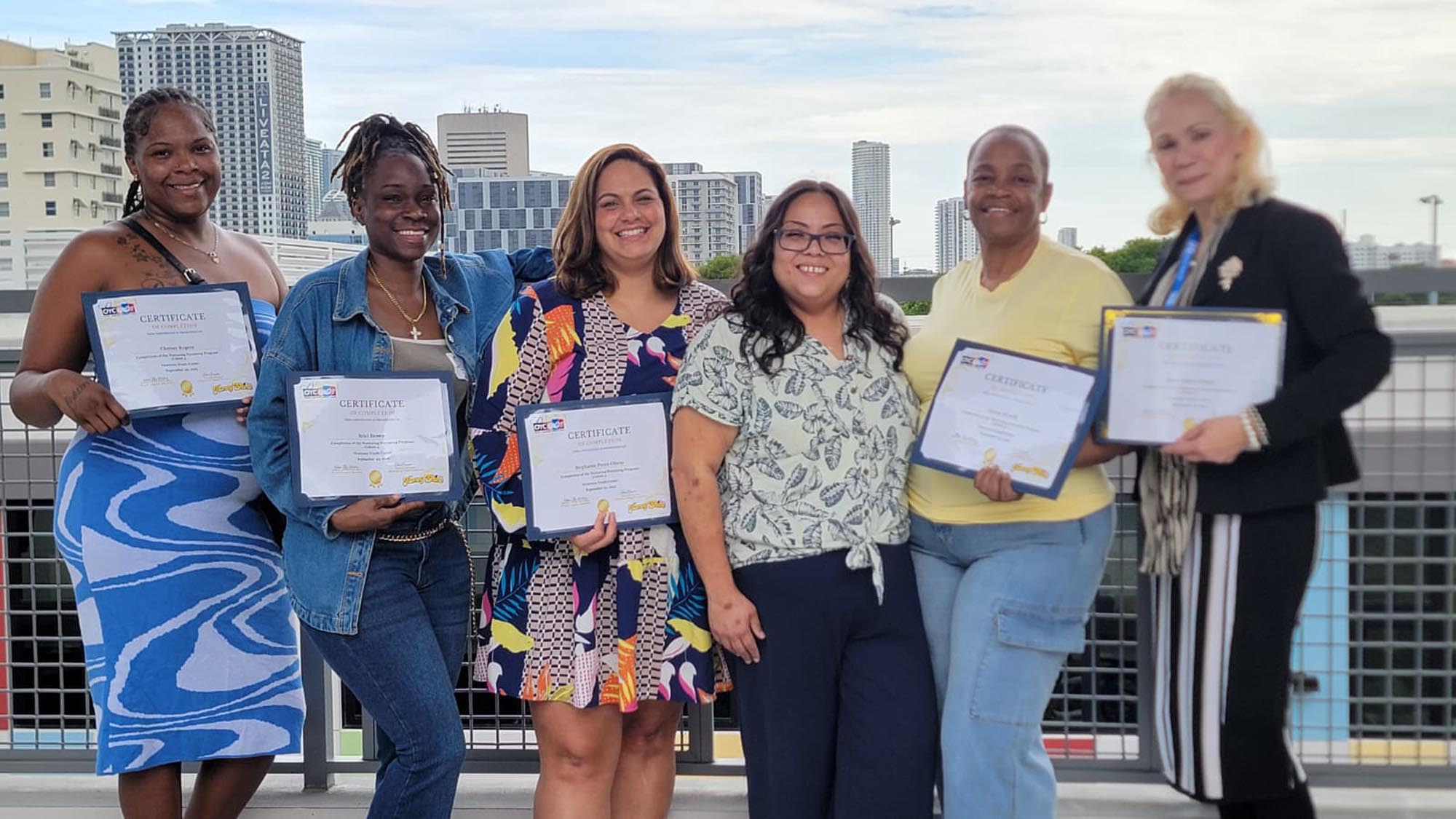recent graduates of OYC's Nurturing Parenting Program display their certificates of completion