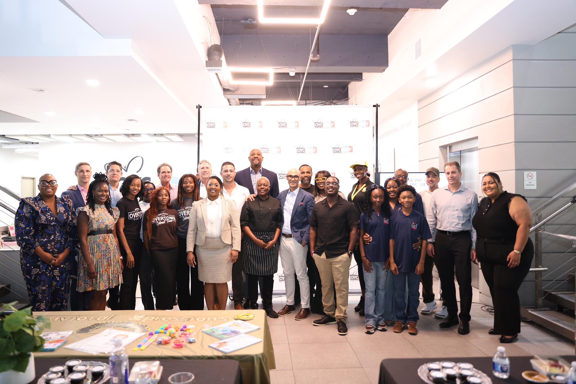 a group pf people in business attire stand for a photo in a conference room