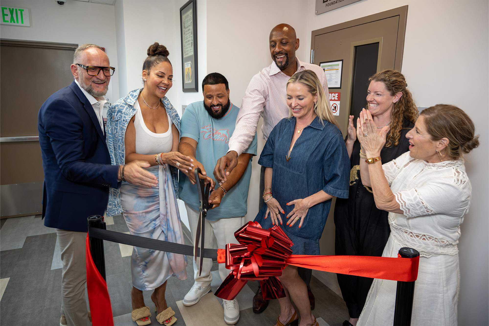 DJ Khaled, Alonzo Mourning, Tracy Wilson Mourning cut a ceremonial ribbon as several other people look on