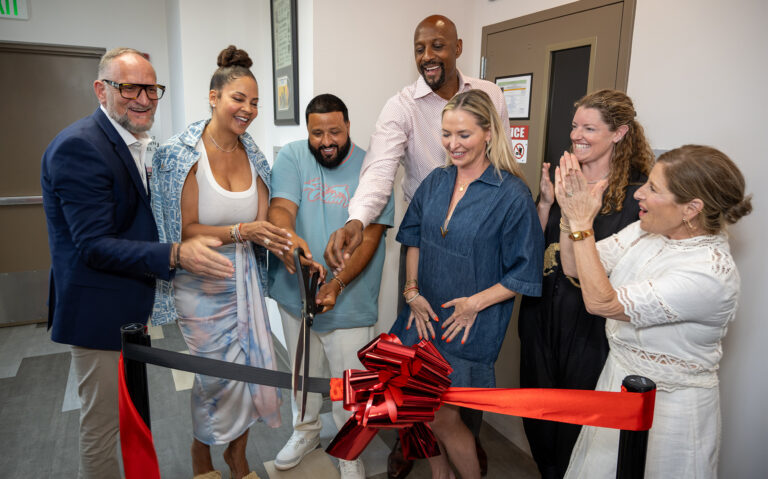 DJ Khaled, Alonzo Mourning, Tracy Wilson Mourning cut a ceremonial ribbon as several other people look on