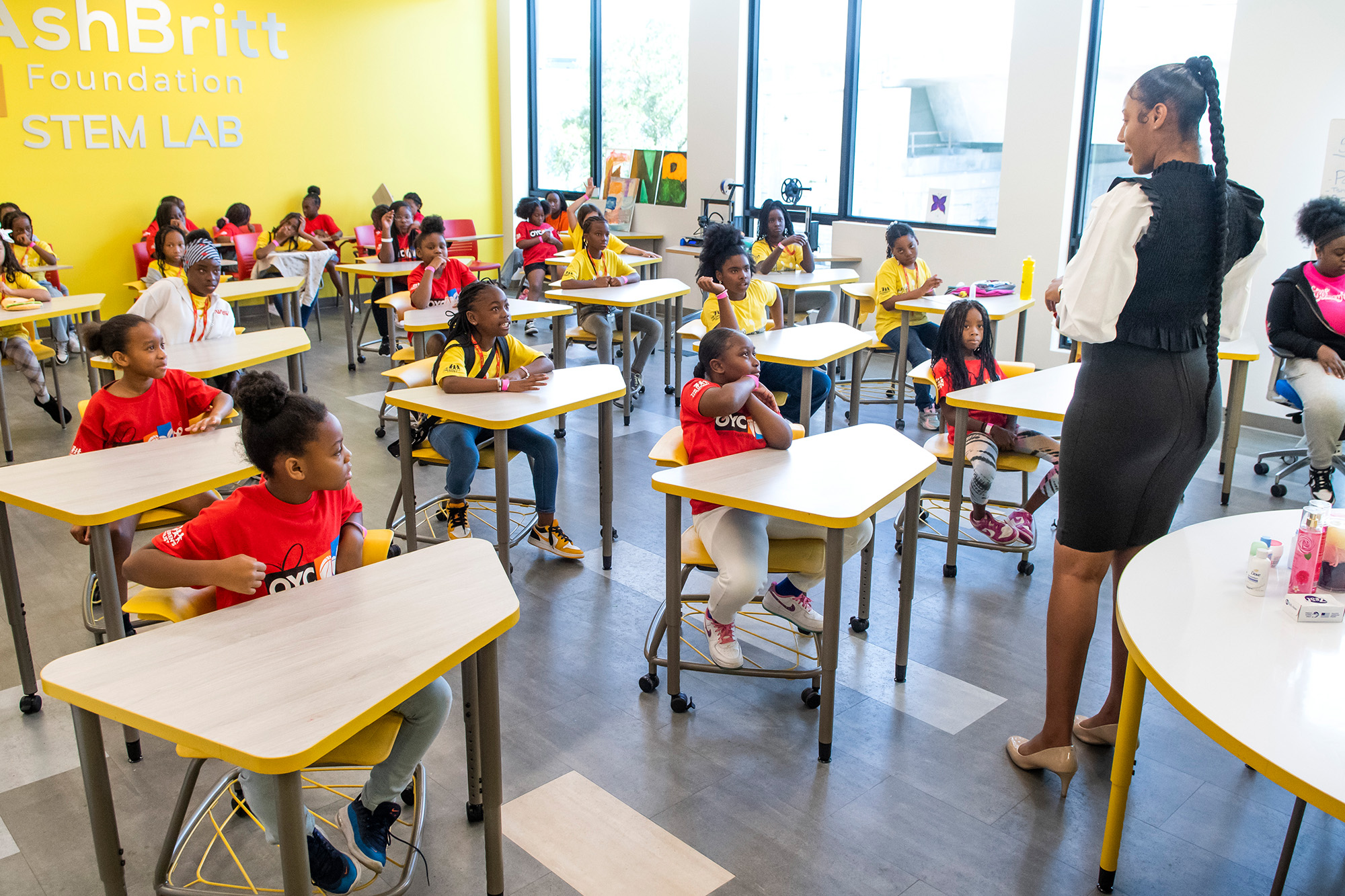 a teacher instructs a classroom full of elementary school children.