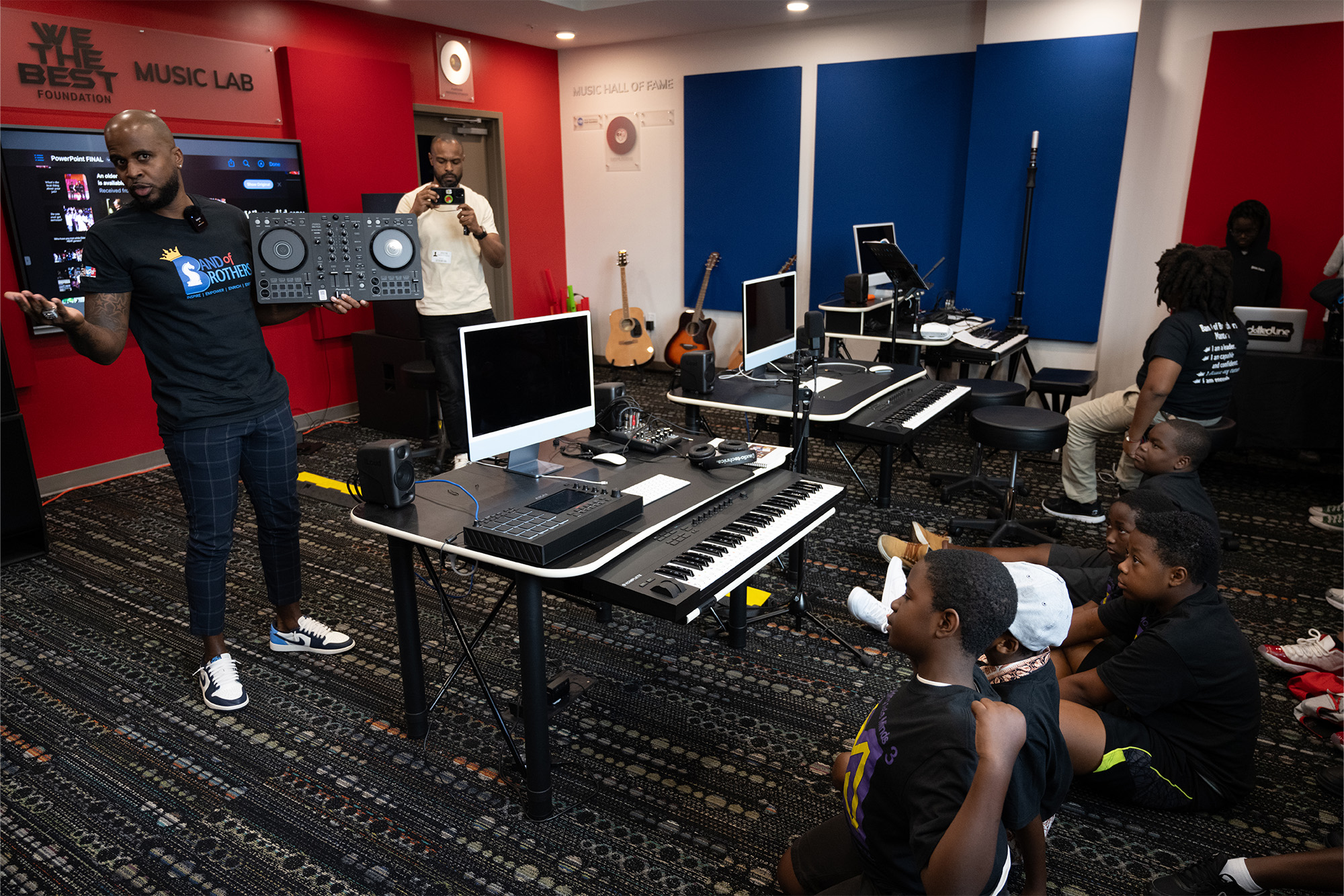 an instructor holding a DJ controller teaches a classroom of young children