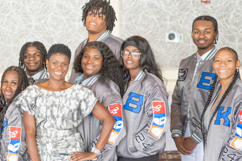a group of high school seniors and Tina Brown, CEO, pose for a photo at the senior banquet event.