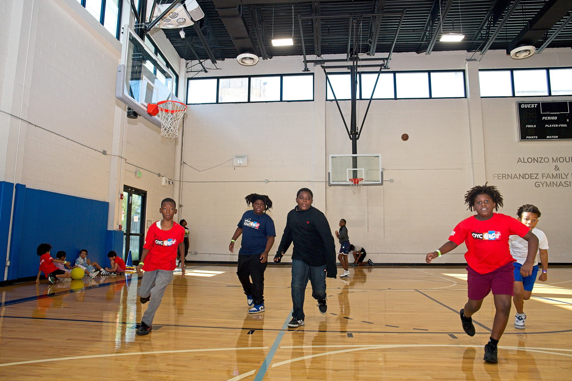 a group of boys plays basketball in a gymnasium
