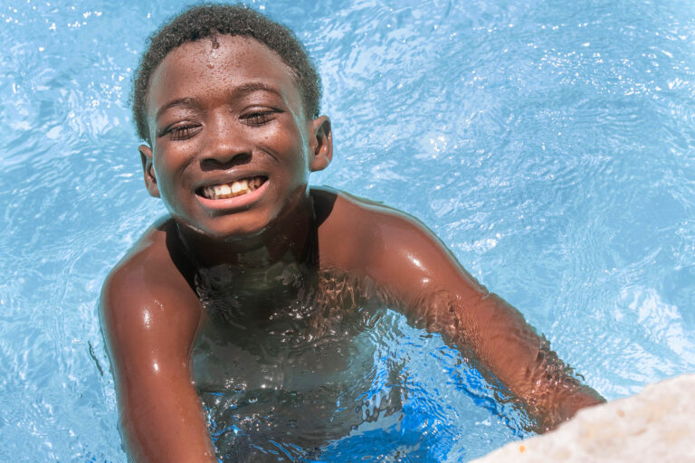 a smiling boy in a pool