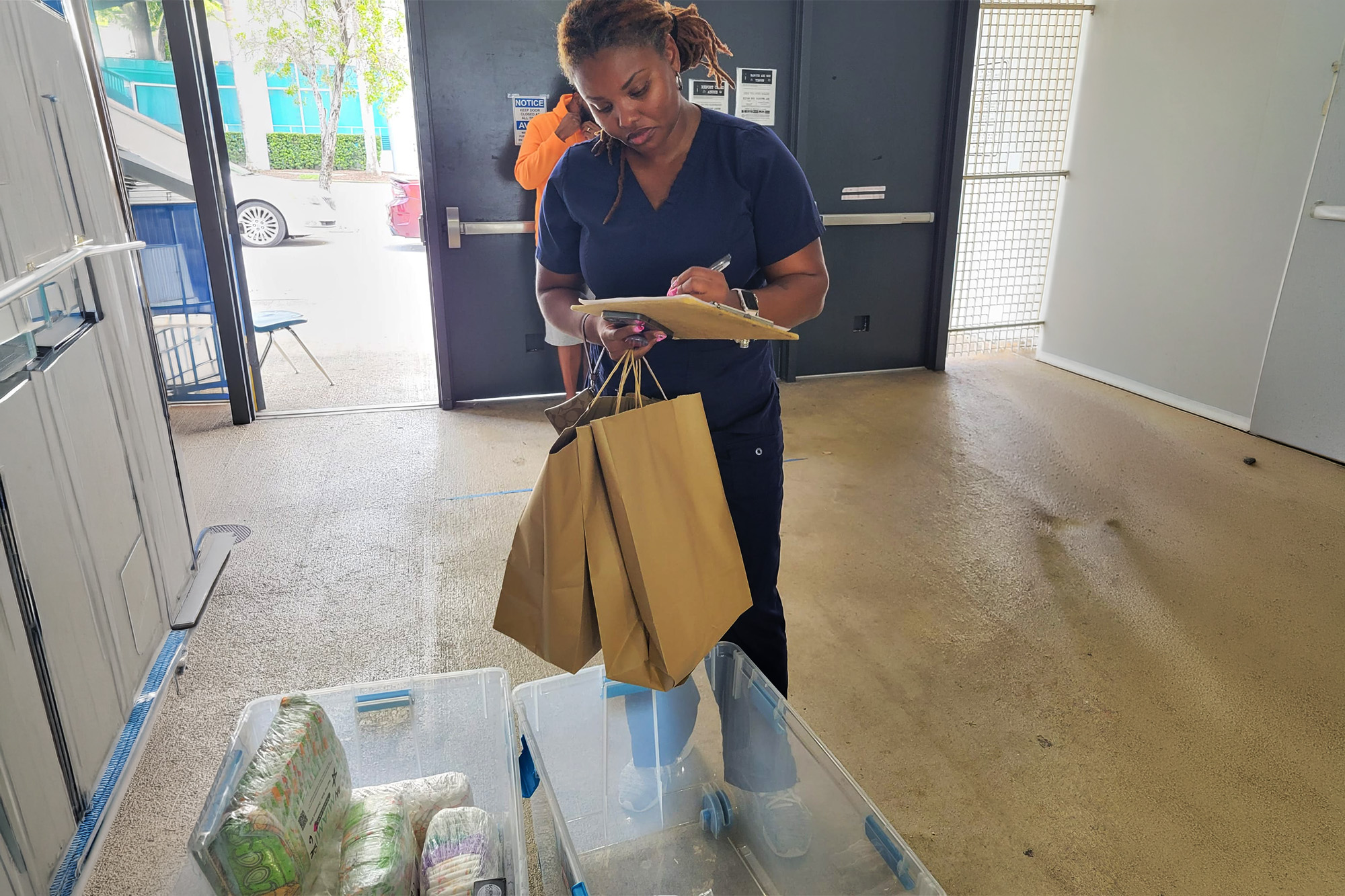a woman fills bags with donations for the EDEN Place program