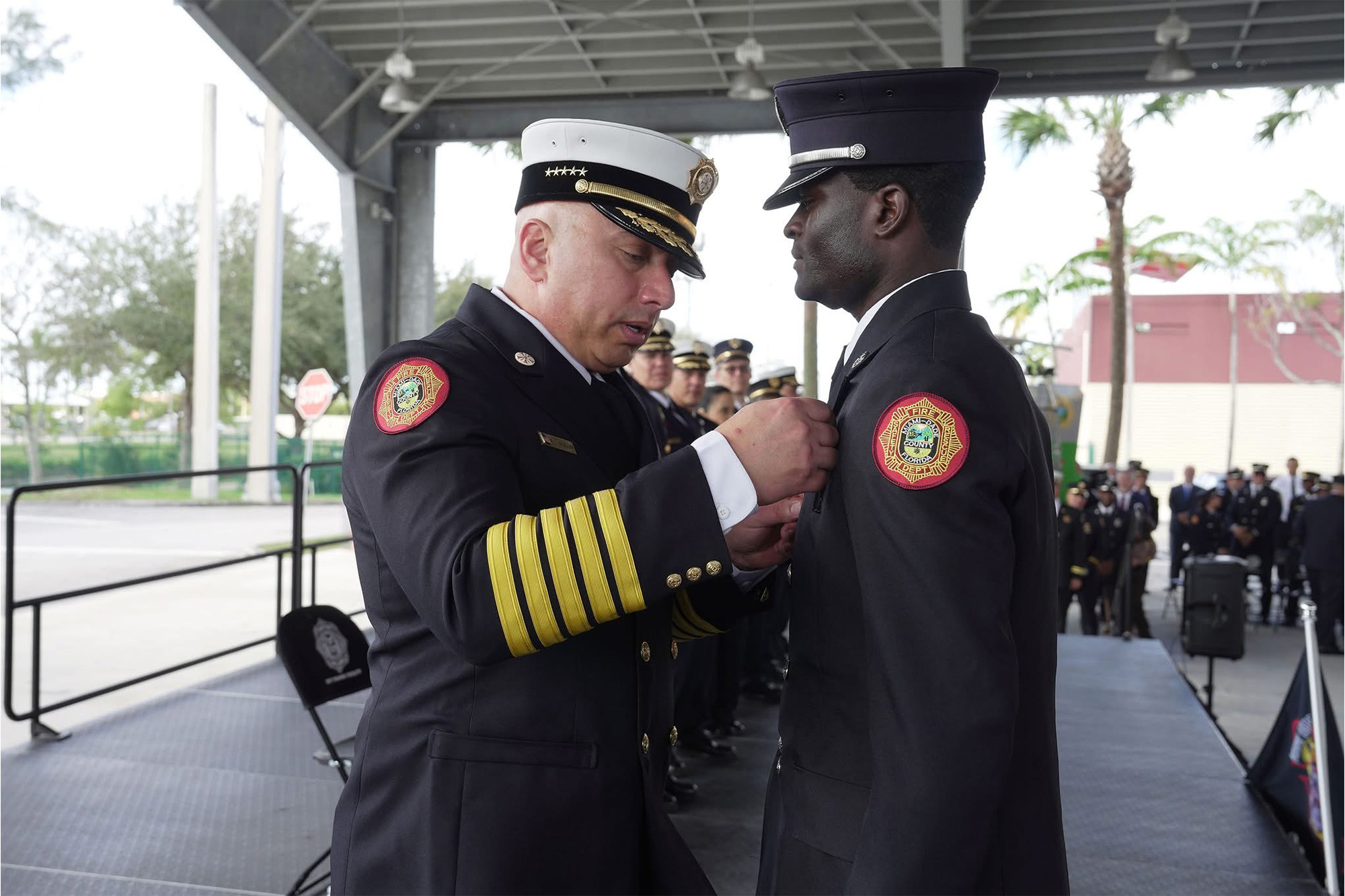 a fire chief pins a badge on a new recruit